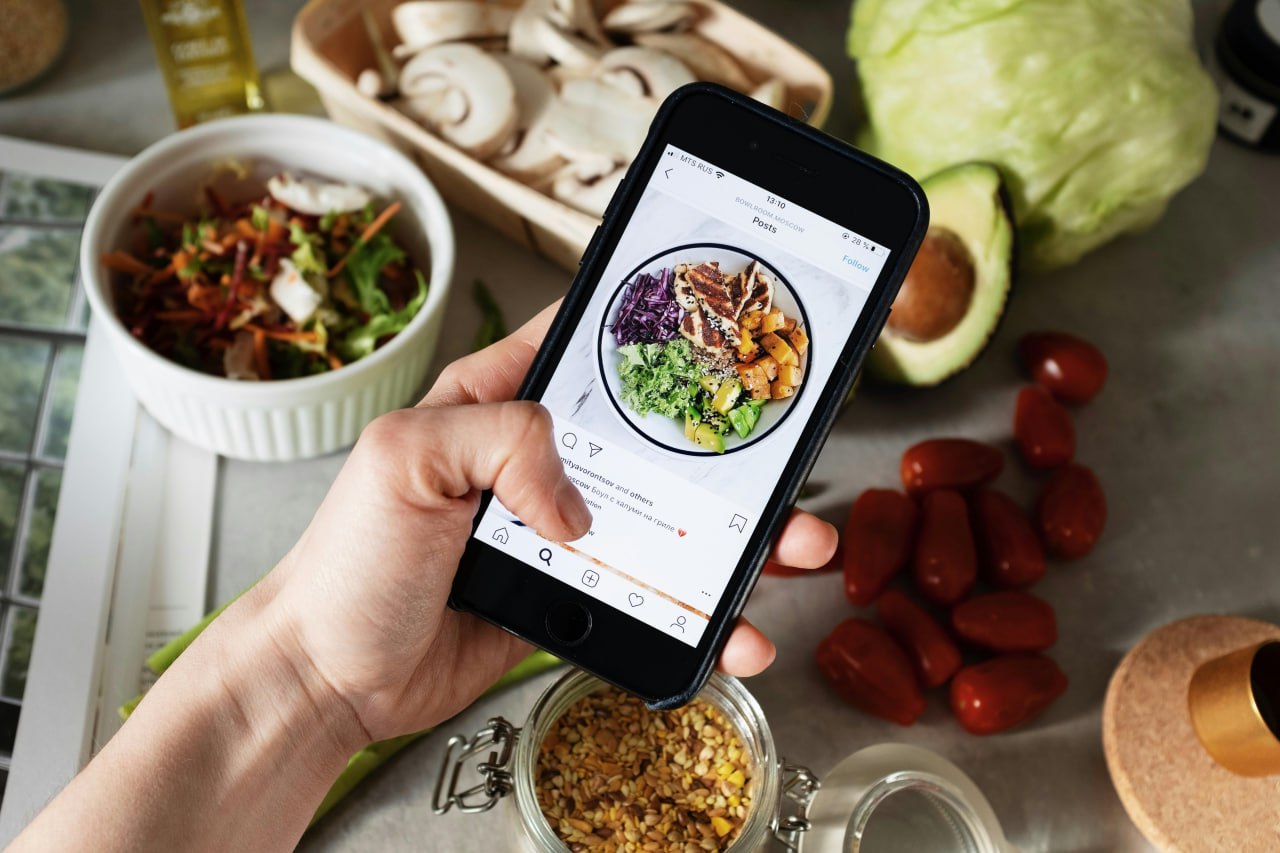 Tracking a meal on your phone surrounded by fresh ingredients
